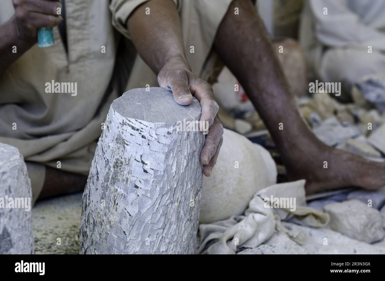 Mani di uno scultore egiziano maschio mentre lavora con un alabastro di pietra Foto Stock