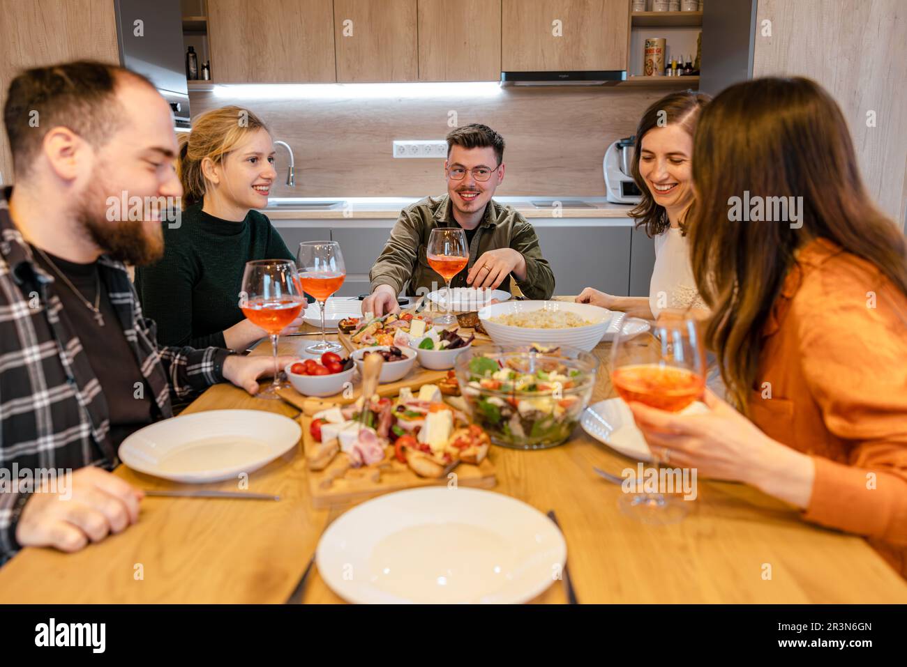 Amici che si divertono a mangiare insieme e a ridere Foto Stock