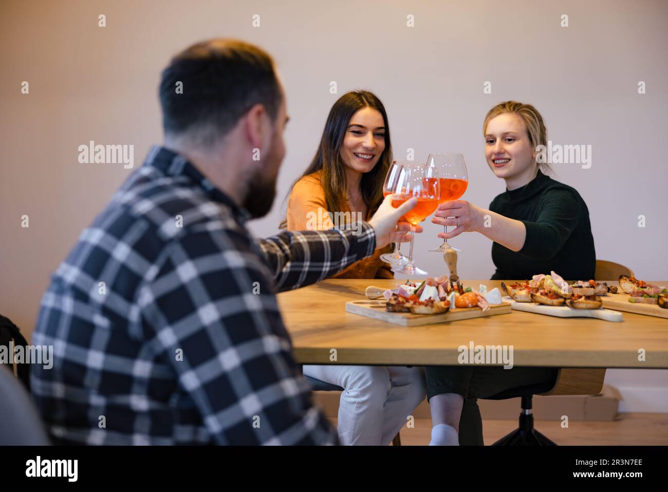 Gli amici sorridono e si gustano un brindisi Foto Stock