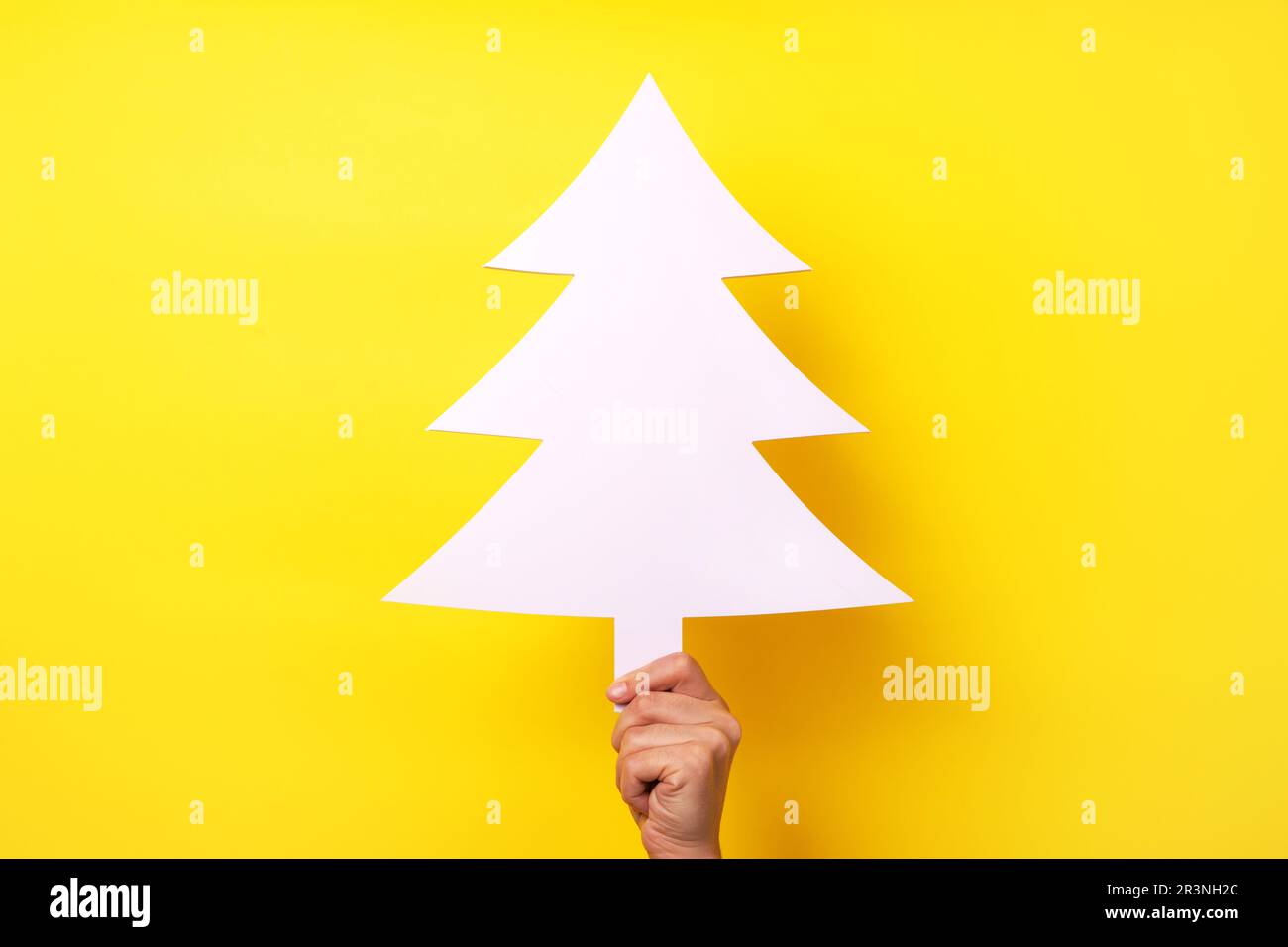 Mano che tiene albero di natale Foto Stock