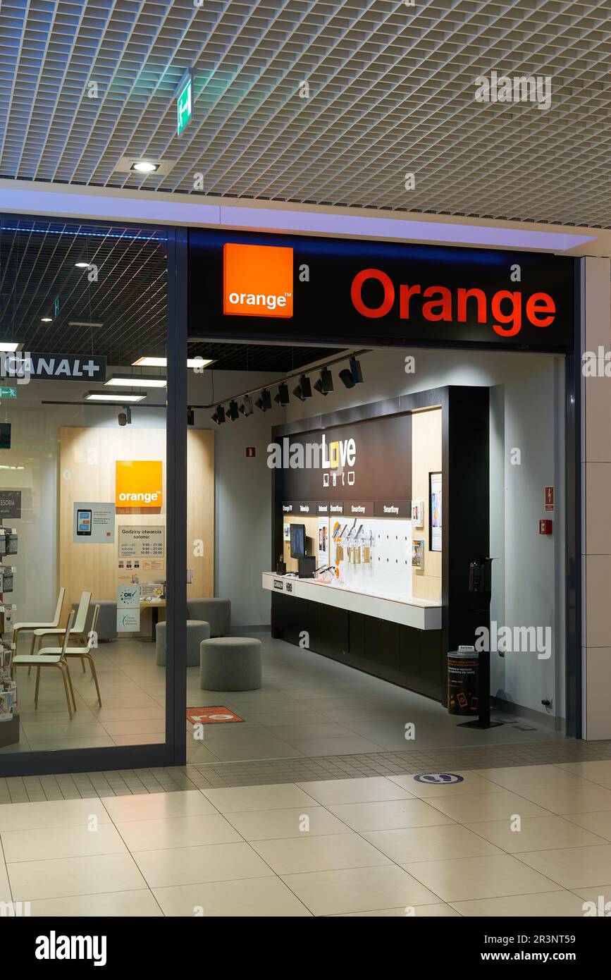 Insegna illuminata della società di telecomunicazioni francese Orange in un negozio in Polonia Foto Stock