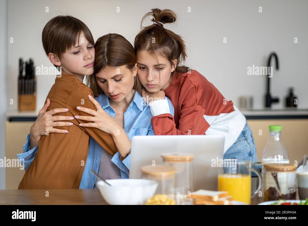 Bambini che abbracciano e sostengono la madre single stanca a casa Foto Stock