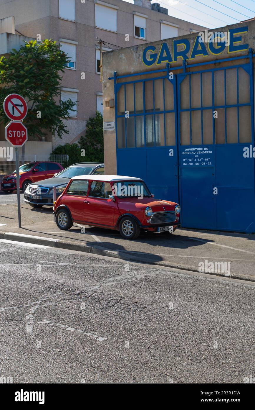 Vecchio rosso e bianco Mini Cooper accanto al garage in Francia Foto Stock