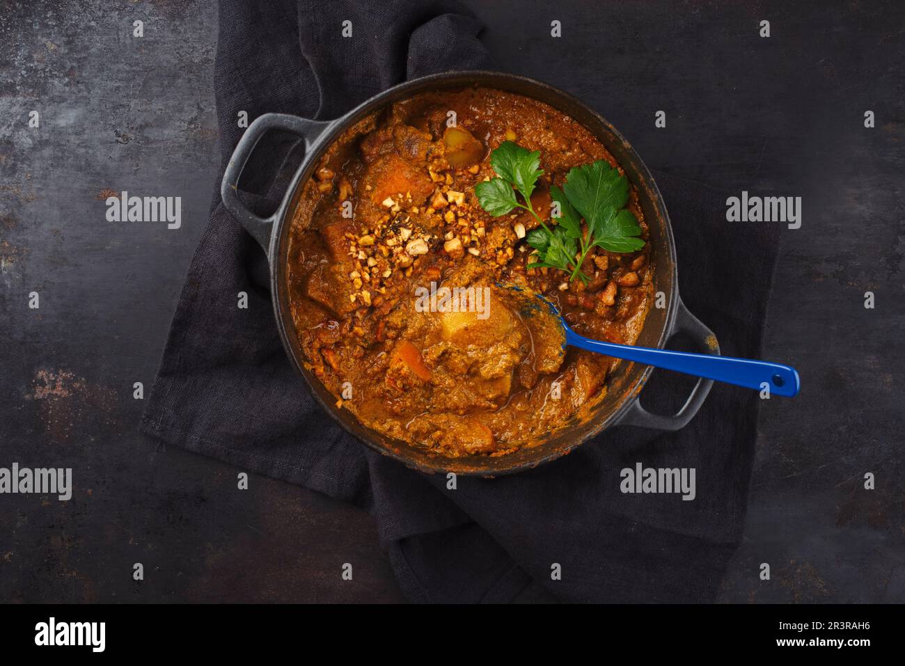 Tradizionale stufato di curry indiano vegetariano Madras con patate dolci e noci di anacardi arrosto servito come vista dall'alto in una padella con Foto Stock