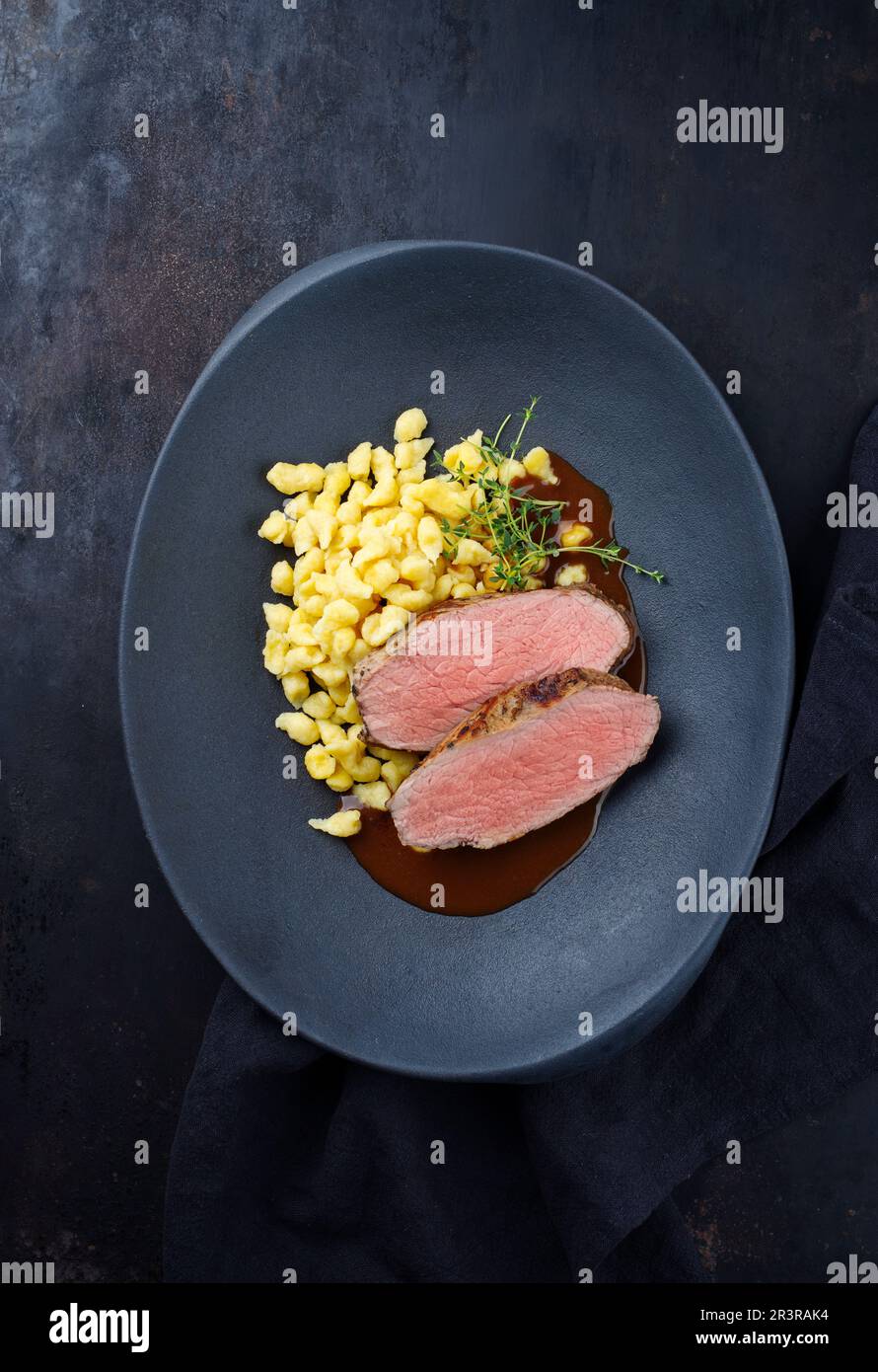 Fettine di vitello arrosto Tafelspitz con spaetzle sveva servite con salsa di birra scura come vista dall'alto in un piatto di design con spazio copia Foto Stock