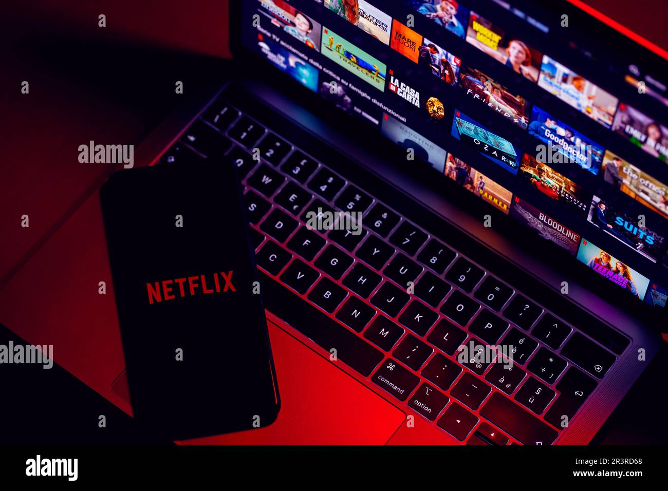 ITALIA - 24 maggio 2023: Pagina iniziale di Netflix sullo schermo di un computer portatile Mac e logo con lettere sullo schermo dello smartphone. Netflix è uno streaming video online Foto Stock