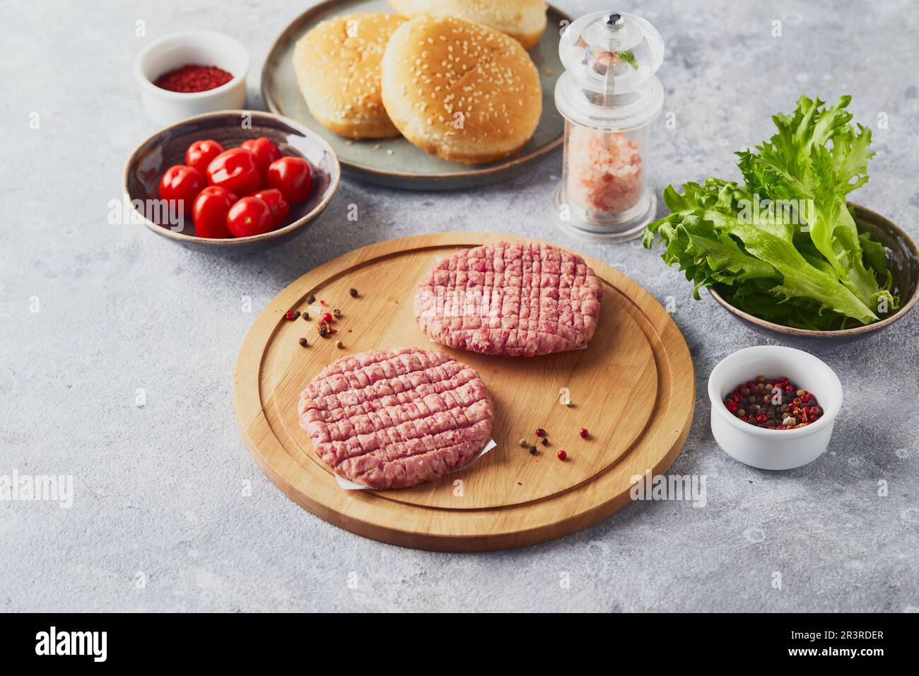 Cotolette di bistecca di vitello crudo al Burger su tagliere in legno Foto Stock