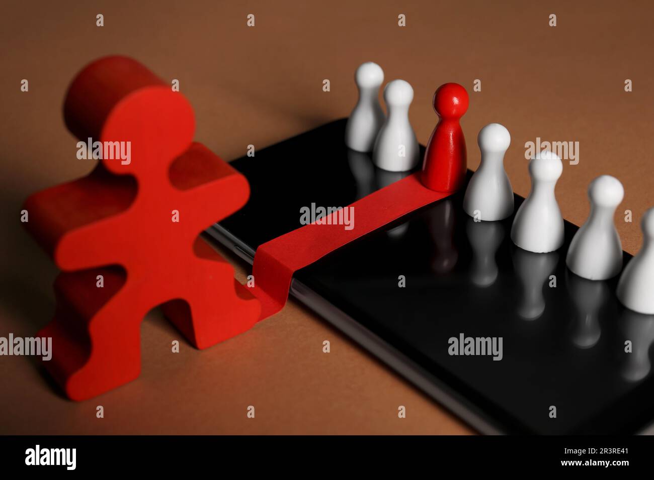 Processo di reclutamento, concetto di competizione di lavoro. Pedina rossa tra quelle bianche come miglior candidato scelto dalla figura umana su sfondo marrone chiaro Foto Stock