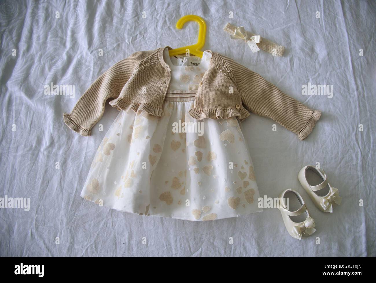 Sfondo battesimale con vestito e scarpe per il battesimo Foto Stock