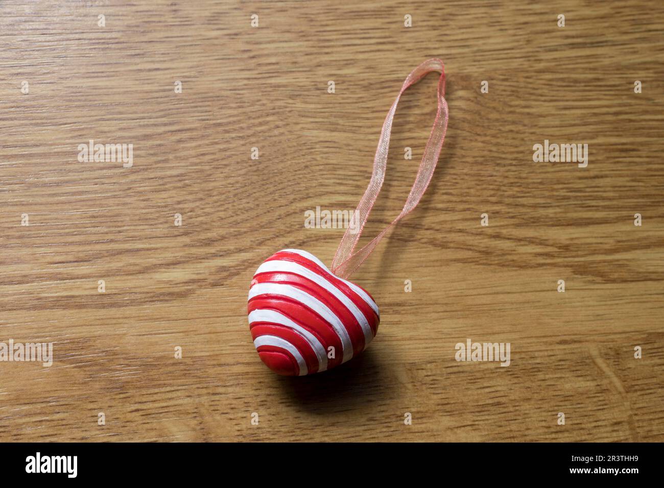 Pendente a forma di cuore su piastra di legno per decorazione Foto Stock