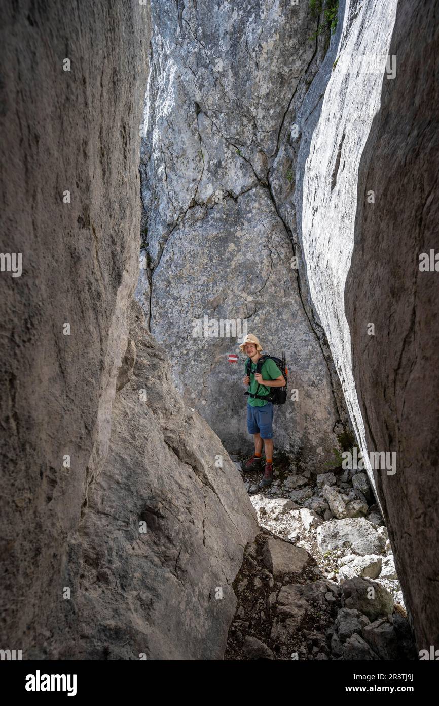 Arrampicatori in uno stretto passaggio roccioso, sul Mannlsteig, via ferrata sul Goell Hohe, paesaggio montano, Alpi Berchtesgaden, terra Berchtesgadener Foto Stock