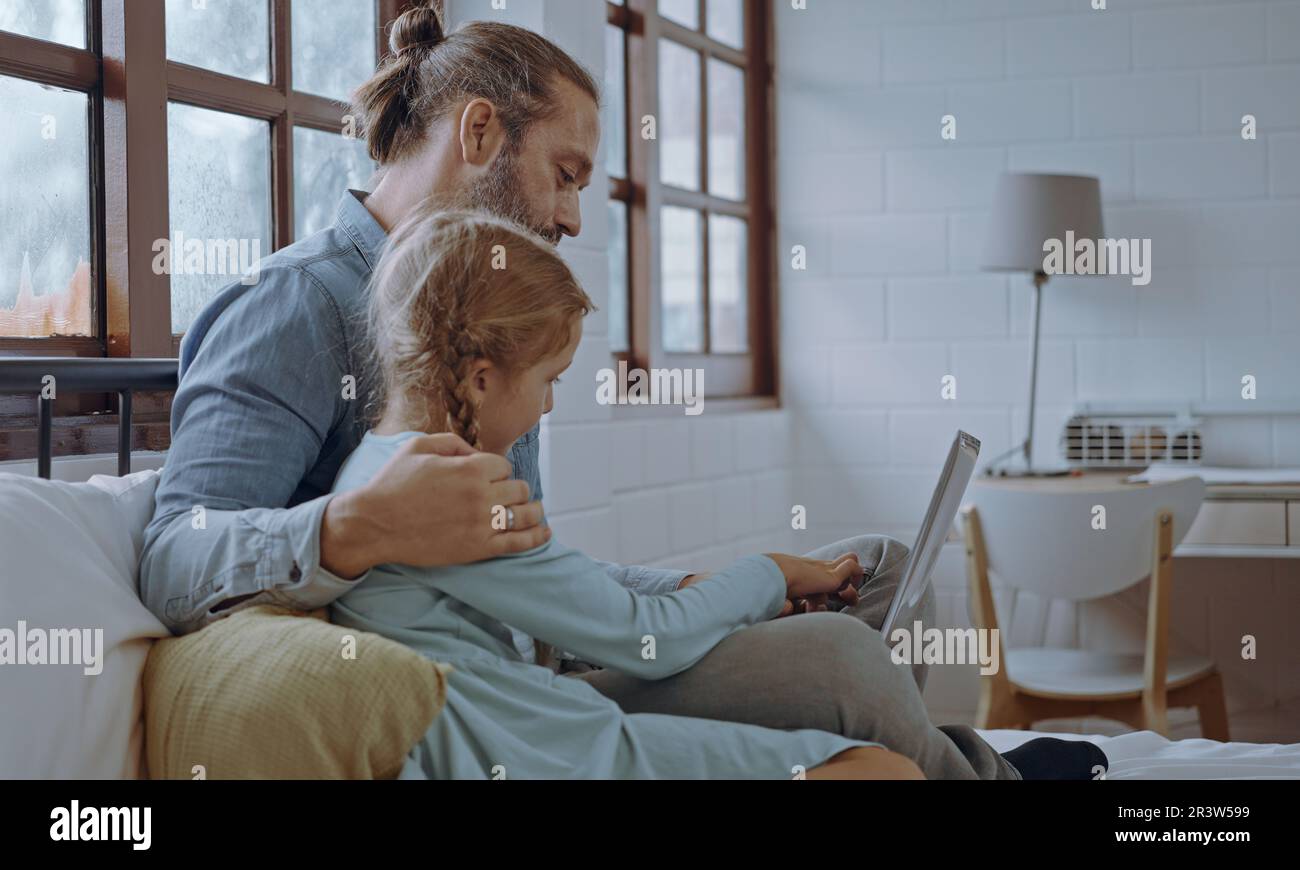 Padre che usa un computer portatile con una bambina. Famiglia felice, la sensazione del Padre rilassarsi e godere di lavorare online a casa con la ragazza carina poco a letto in Foto Stock