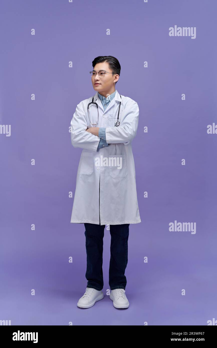 Ritratto di giovane medico asiatico maschio su sfondo blu Foto Stock