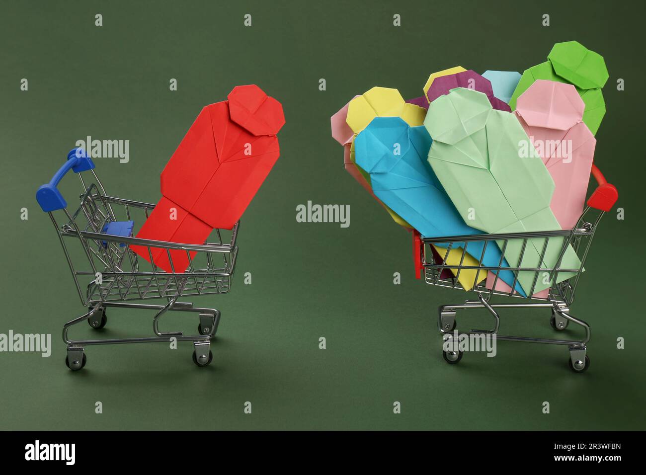 Processo di reclutamento, concetto di competizione di lavoro. Composizione con figure umane di carta e carrelli da shopping giocattolo su sfondo verde Foto Stock