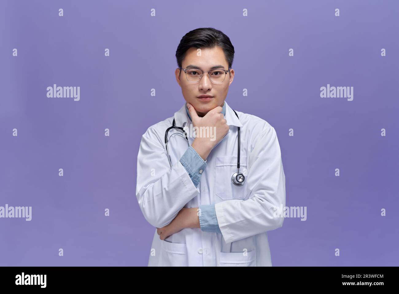Medico asiatico maschio in scrub alla ricerca di idea pensare, alla ricerca di soluzione Foto Stock