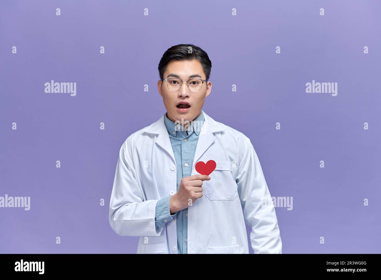 cardiologo medico uomo che tiene il cuore rosso, infastidito e frustrato gridare con rabbia, Foto Stock