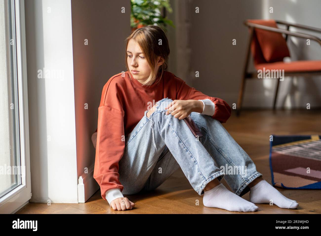 La ragazza dell'adolescenza del upset si siede sul pavimento soffre preoccupata per bullismo a scuola, i rapporti difettosi con i genitori Foto Stock