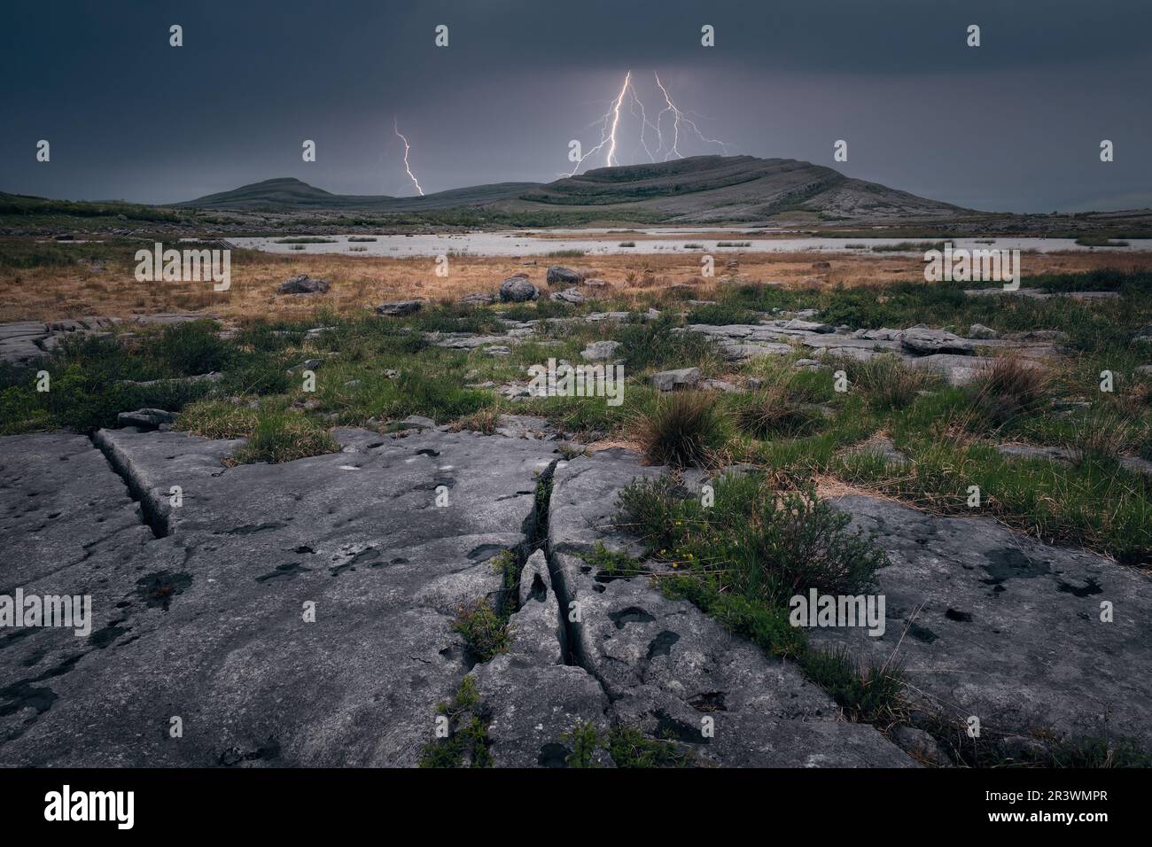 Scenario paesaggistico drammatico e nuvoloso con tempesta di temporali sulle montagne vicino al lago al Parco Nazionale di Burren nella Contea di Clare, Irlanda Foto Stock