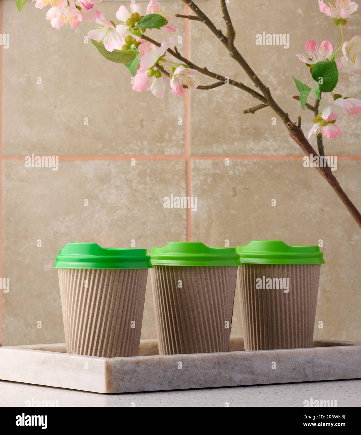 Tazze di carta marrone con coperchio verde in plastica per caffè e tè Foto Stock