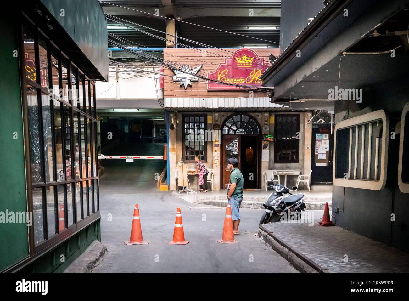 La vista lungo il piccolo vicolo che collega Soi 1 e Soi 2 a Patpong, il famoso quartiere a luci rosse di Bangkok. Crown Royal Pub visto alla fine Foto Stock