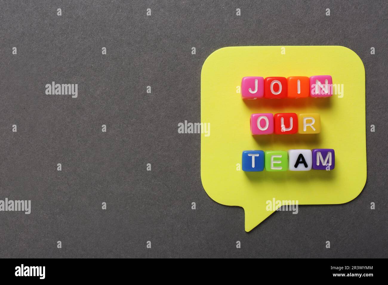 Concetto del processo di reclutamento. Frase Unisciti al nostro team fatto di cubi colorati su sfondo grigio, piatto. Spazio per il testo Foto Stock