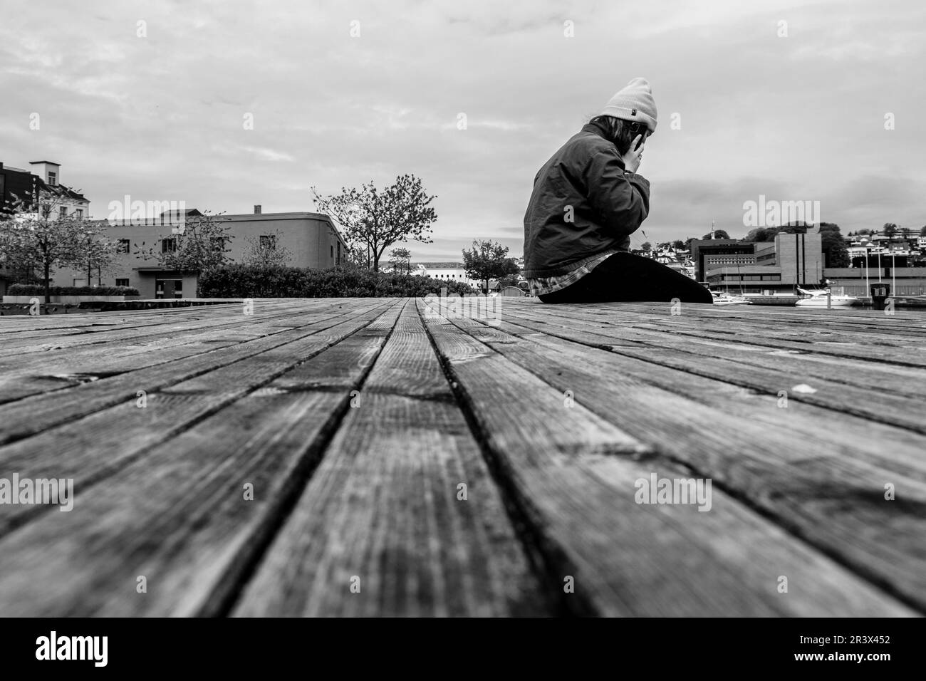 Sandnes, Norvegia, 18 2023 maggio, uomo seduto da solo su Una passerella o molo in legno intatto a Sandnes Harbour Foto Stock