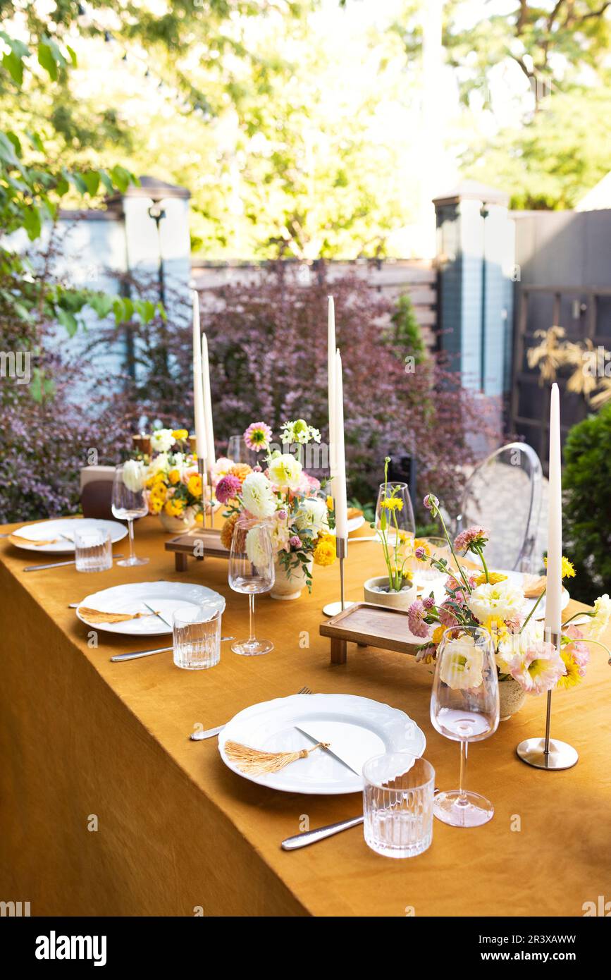 Tavolo da matrimonio per gli ospiti, decorato con candele, sono serviti con  posate e stoviglie e coperti con tovaglia gialla Foto stock - Alamy