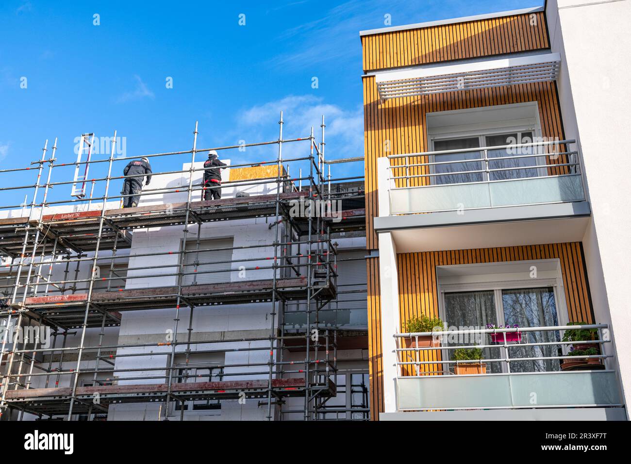 Riabilitazione termica di edifici di appartamenti. Ristrutturazione di facciate con installazione di coibentazioni e rivestimenti. Isolamento parete esterna, energ Foto Stock