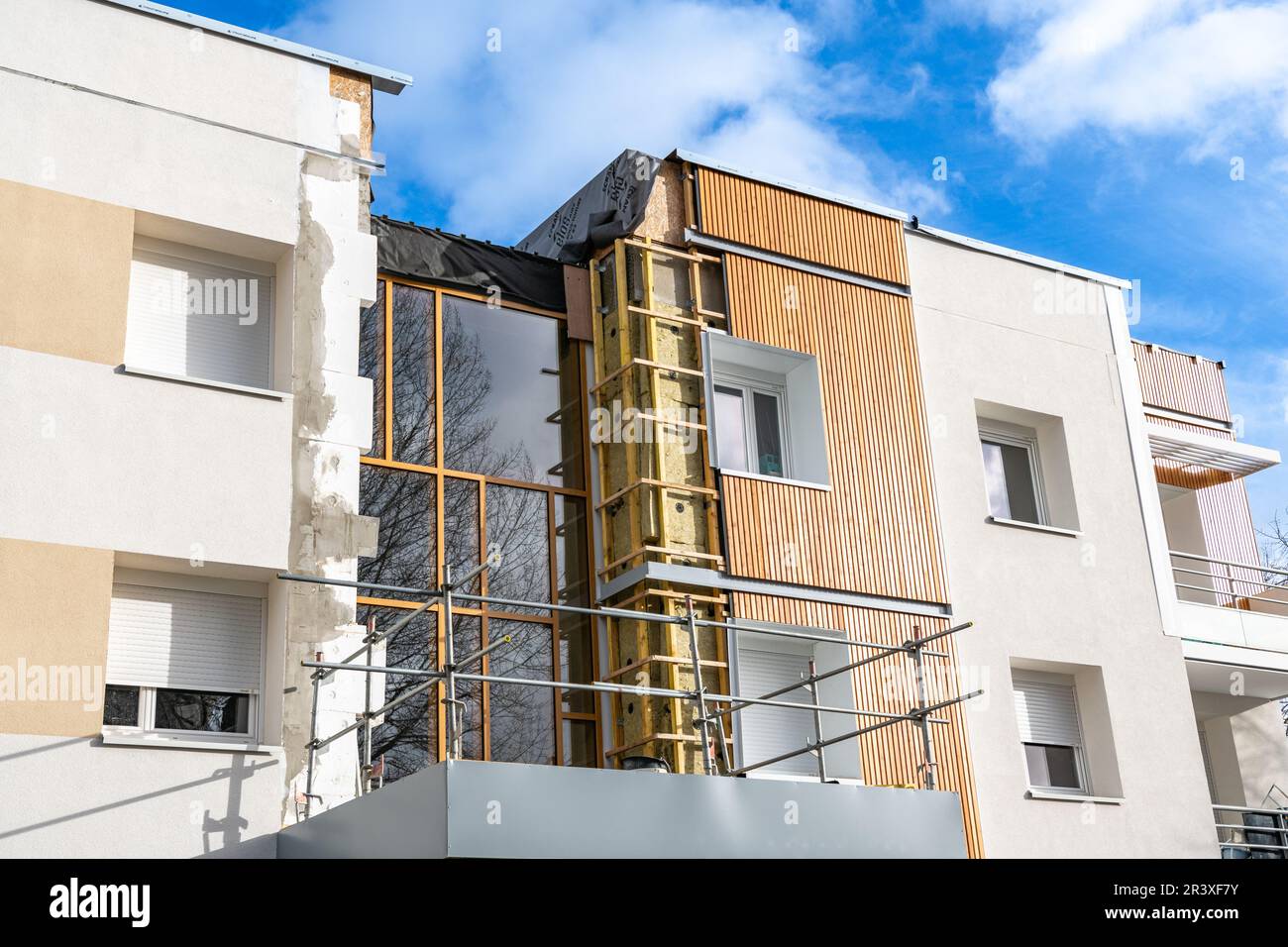 Riabilitazione termica di edifici di appartamenti. Ristrutturazione di facciate con installazione di coibentazioni e rivestimenti. Isolamento parete esterna, energ Foto Stock