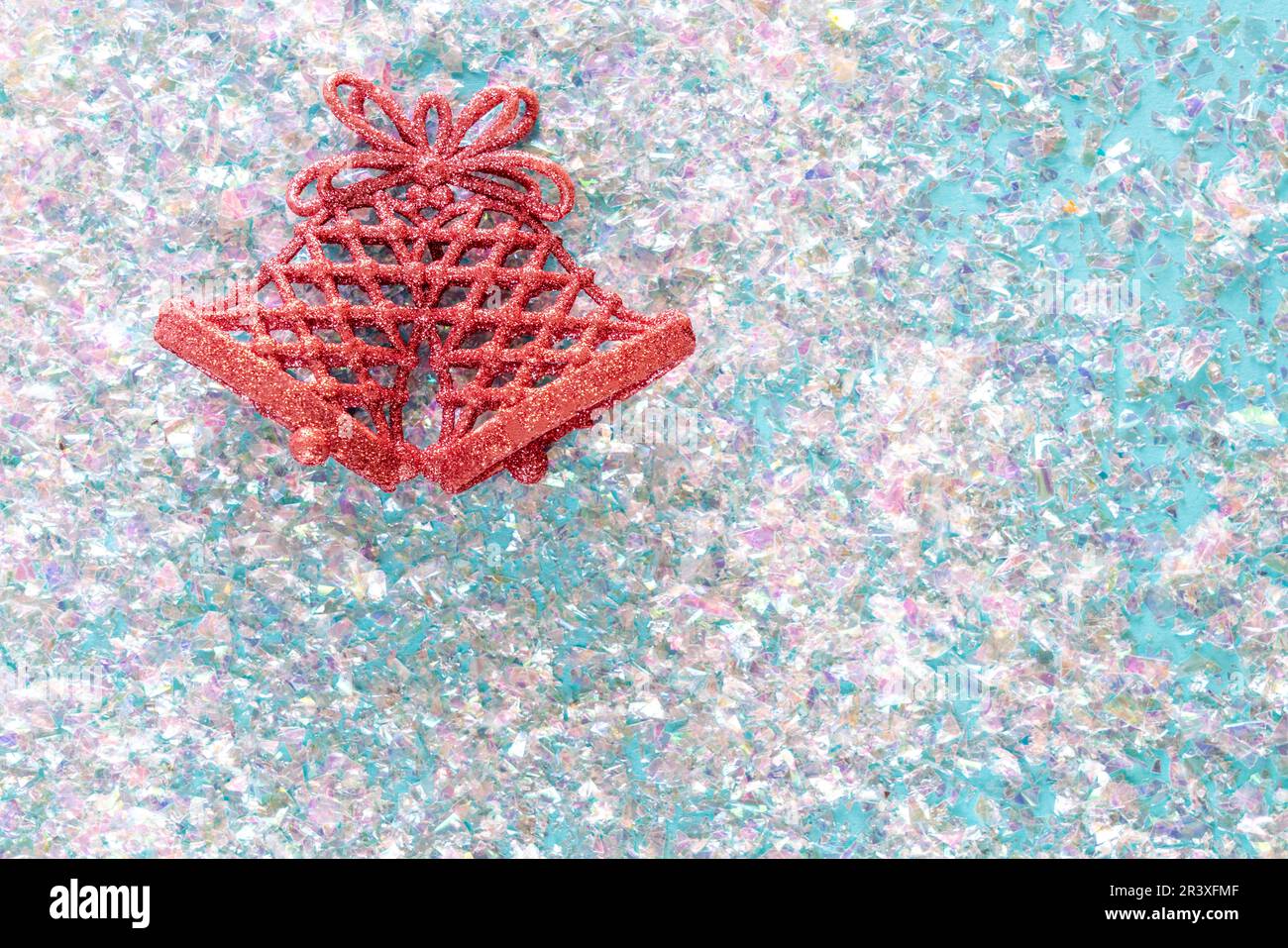 Campana Jingle vintage su sfondo rosa glitter. Concetto di Natale minimo. Felice Anno Nuovo. Disposizione piatta, vista dall'alto, spazio per la copia Foto Stock