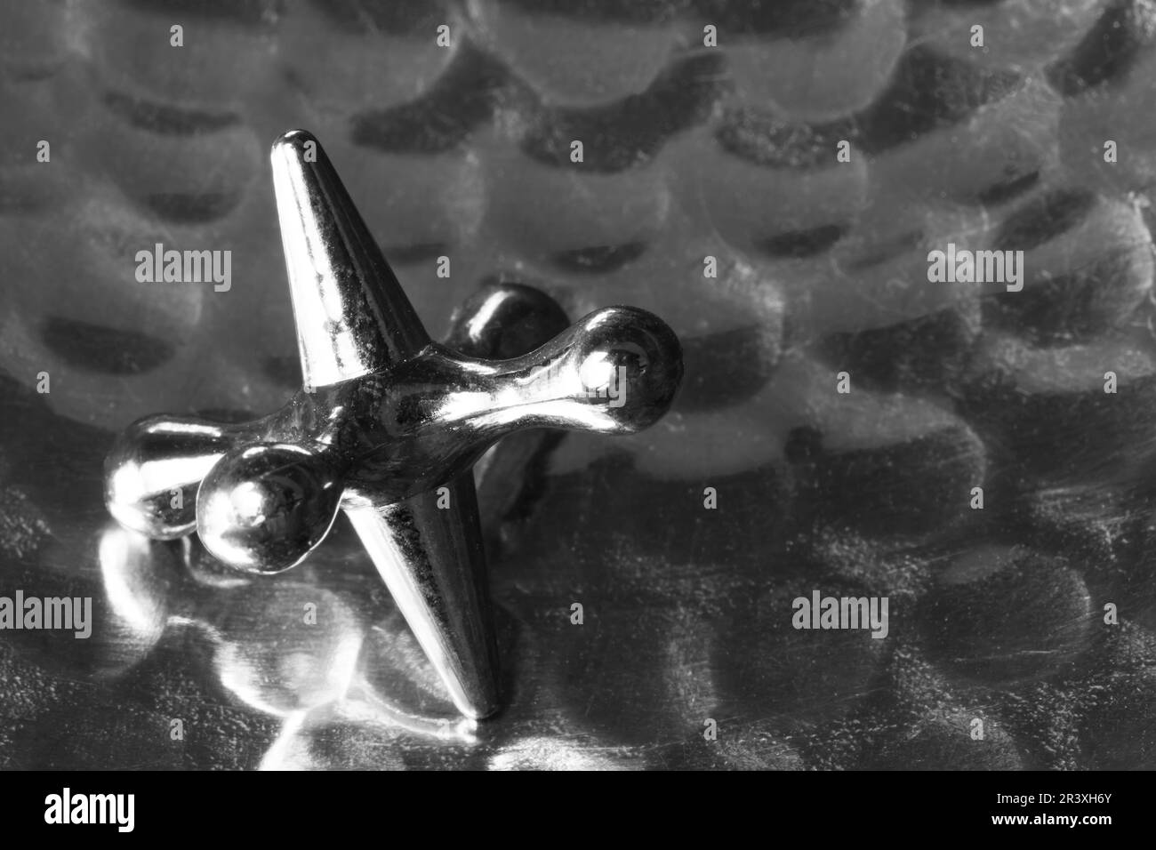 Un pezzo di gioco di jack su uno sfondo di metallo puntinato. Foto Stock