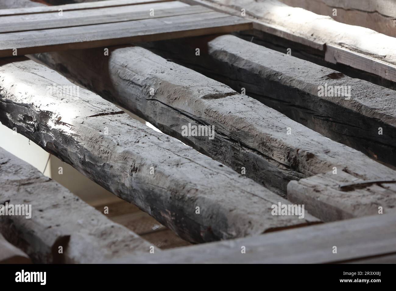 25 maggio 2023, Sassonia-Anhalt, Wernigerode: Vista delle travi originali del 15th ° secolo. Il municipio storico è attualmente in fase di ristrutturazione secondo l'ordine di conservazione. Nell'area della sala si notarono notevoli vibrazioni del pavimento. Quando il soffitto sottostante è stato aperto, è stato determinato che la costruzione esistente (spaziatura e apertura delle travi del soffitto) era troppo debole per l'uso previsto. Pertanto, è obbligatorio un rinforzo strutturale delle travi a soffitto. L'attuazione delle necessarie misure di costruzione deve essere effettuata in cinque costruzioni individuali Foto Stock