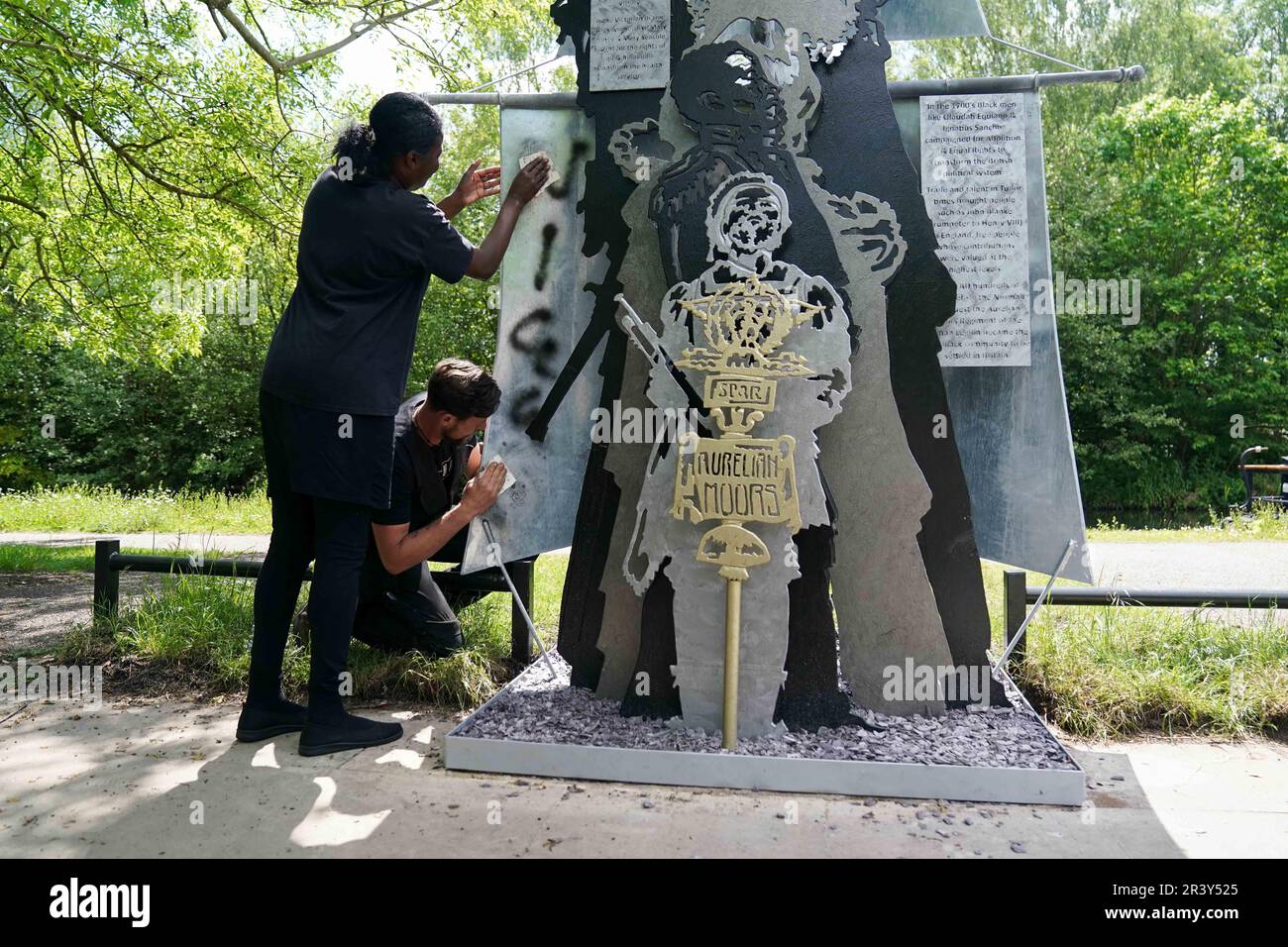 NOTA: LINGUA SULLA SCULTURA marcia Dunkley dal Black Heritage Walks Network e artista Luke Perry pulito razziale slur graffiti fuori dalla sua scultura, la storia britannica nera è la storia britannica, dal Soho Loop Canal a Winson Green, Birmingham dopo che è stato vandalizzato. Data immagine: Giovedì 25 maggio 2023. Foto Stock
