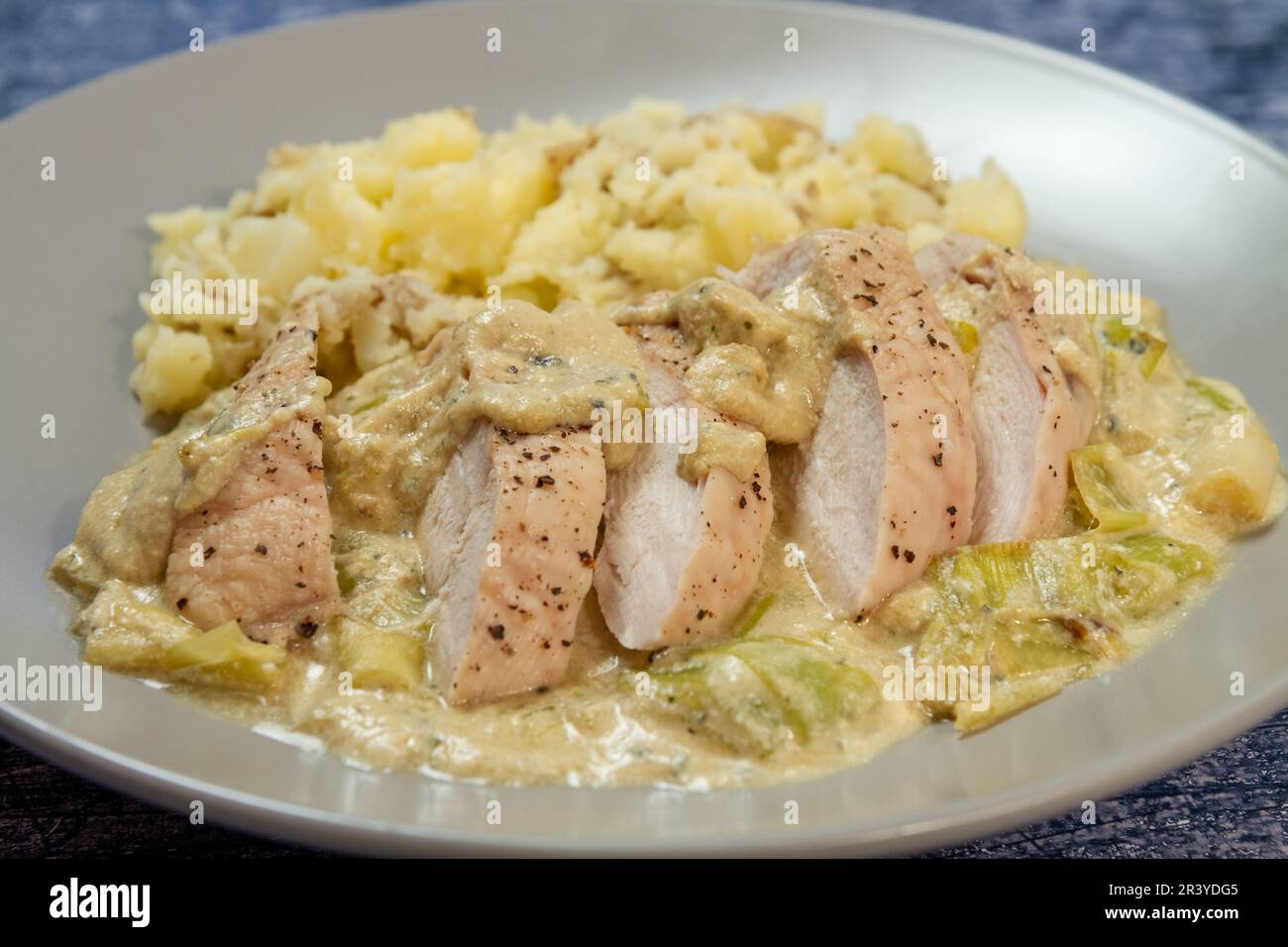 Pollo e porri in salsa di formaggio blu, profondità di campo limitata Foto Stock