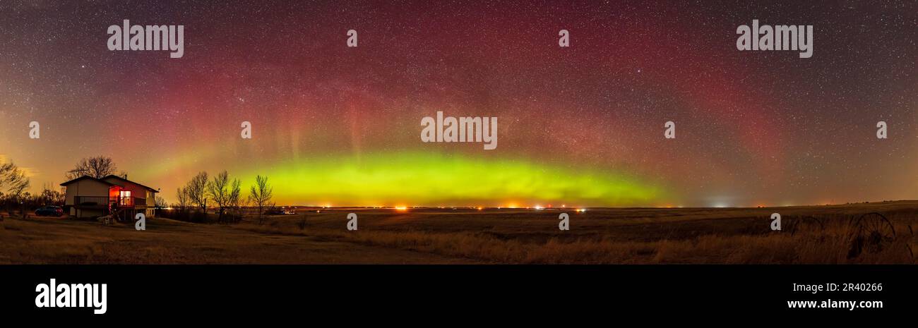 Panorama di un arco aurorale nell'Alberta meridionale, Canada, con la Via Lattea bassa attraverso i paralleli nord dell'aurora. Foto Stock