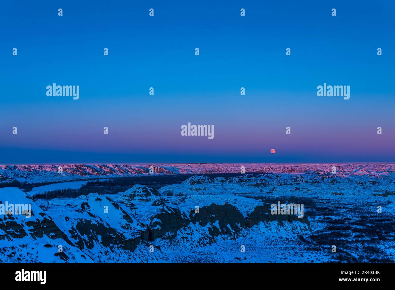 Luna piena che sorge sul Dinosaur Provincial Park, Alberta, Canada, sul Fiume Red Deer. Foto Stock