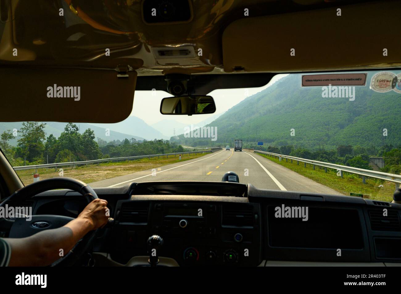 Foto dall'interno di un minibus lungo il tragitto da da Nang a Hue guidando attraverso le montagne sull'autostrada DT601. Foto Stock