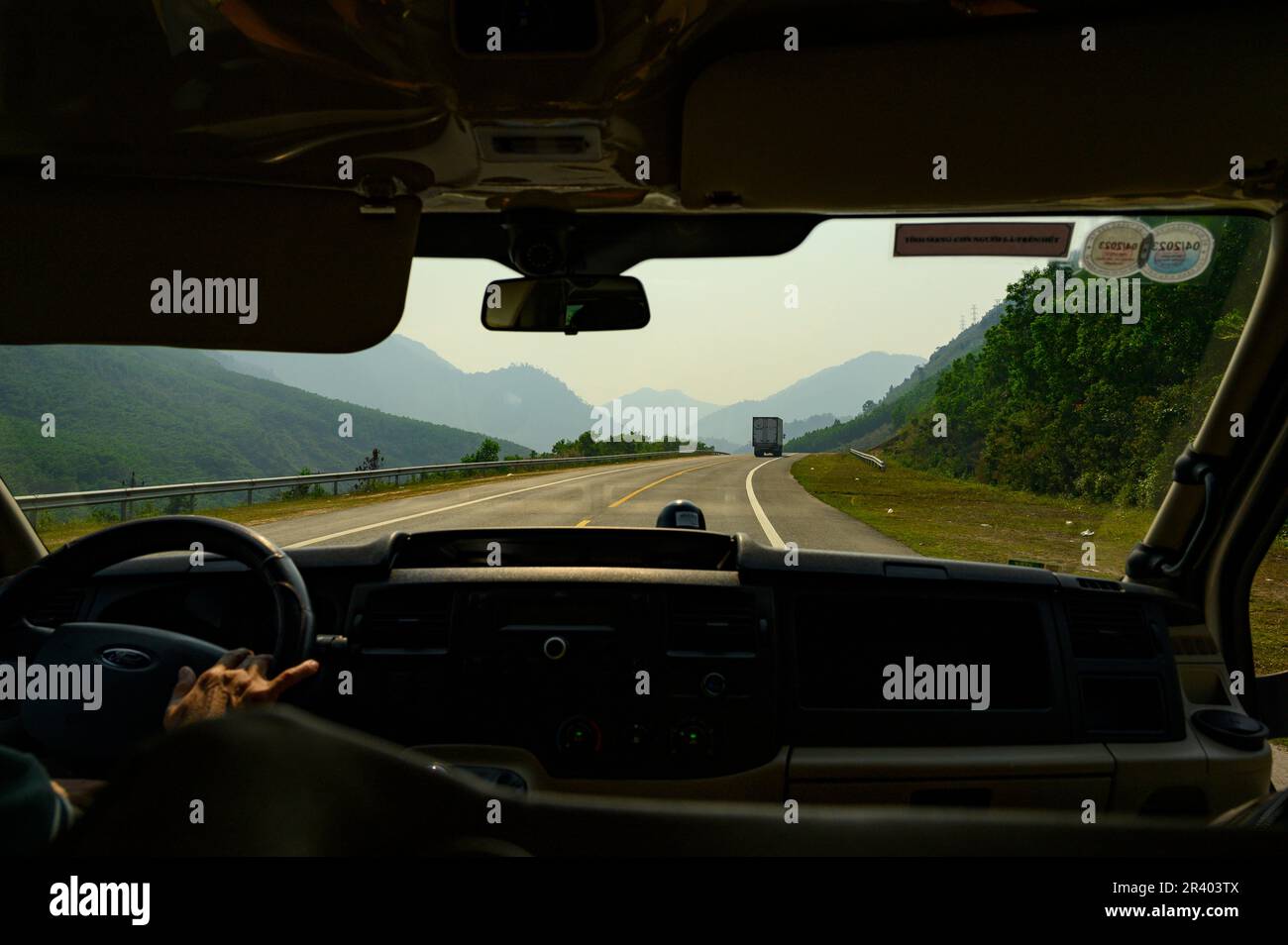 Foto dall'interno di un minibus lungo il tragitto da da Nang a Hue guidando attraverso le montagne sull'autostrada DT601. Foto Stock