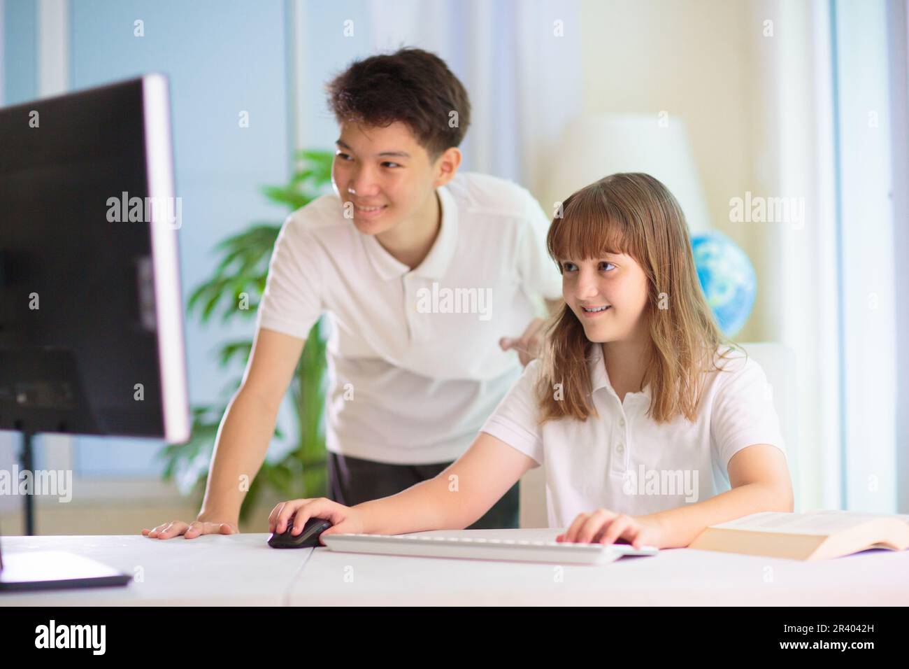 Bambini in classe scolastica. Bambini che lavorano a un progetto scolastico. LEZIONE DI INFORMATICA, codifica e informatica. Adolescente asiatico ragazzo e ragazza caucasica studio. Alto o medio Foto Stock