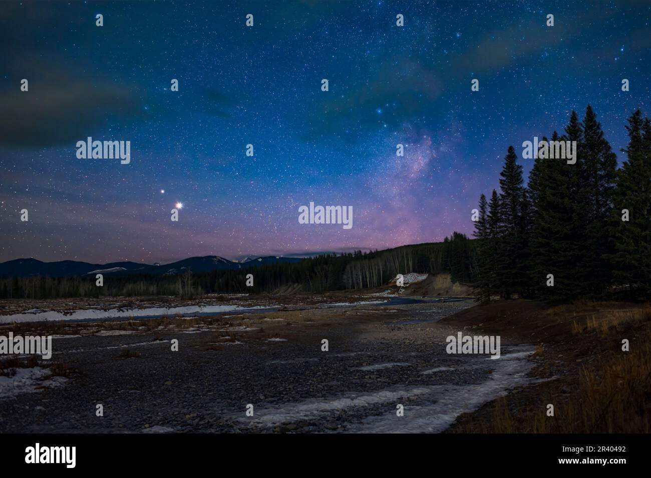 Giove, Saturno e la Via Lattea al crepuscolo sul fiume Elbow, Alberta, Canada. Foto Stock