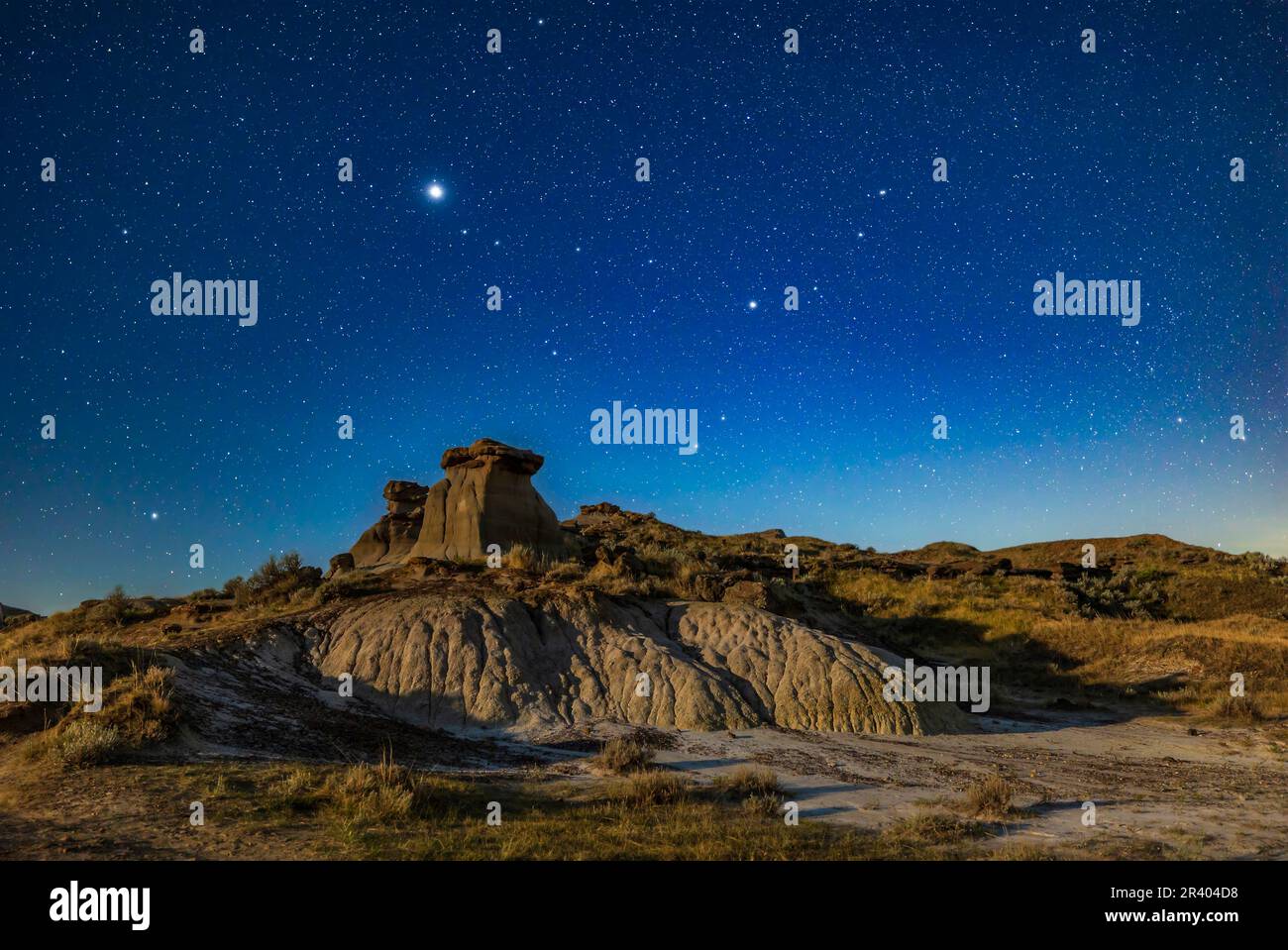 Giove e Saturno sopra le formazioni di hoodoo al Parco Provinciale Dinosaur, Alberta, Canada. Foto Stock