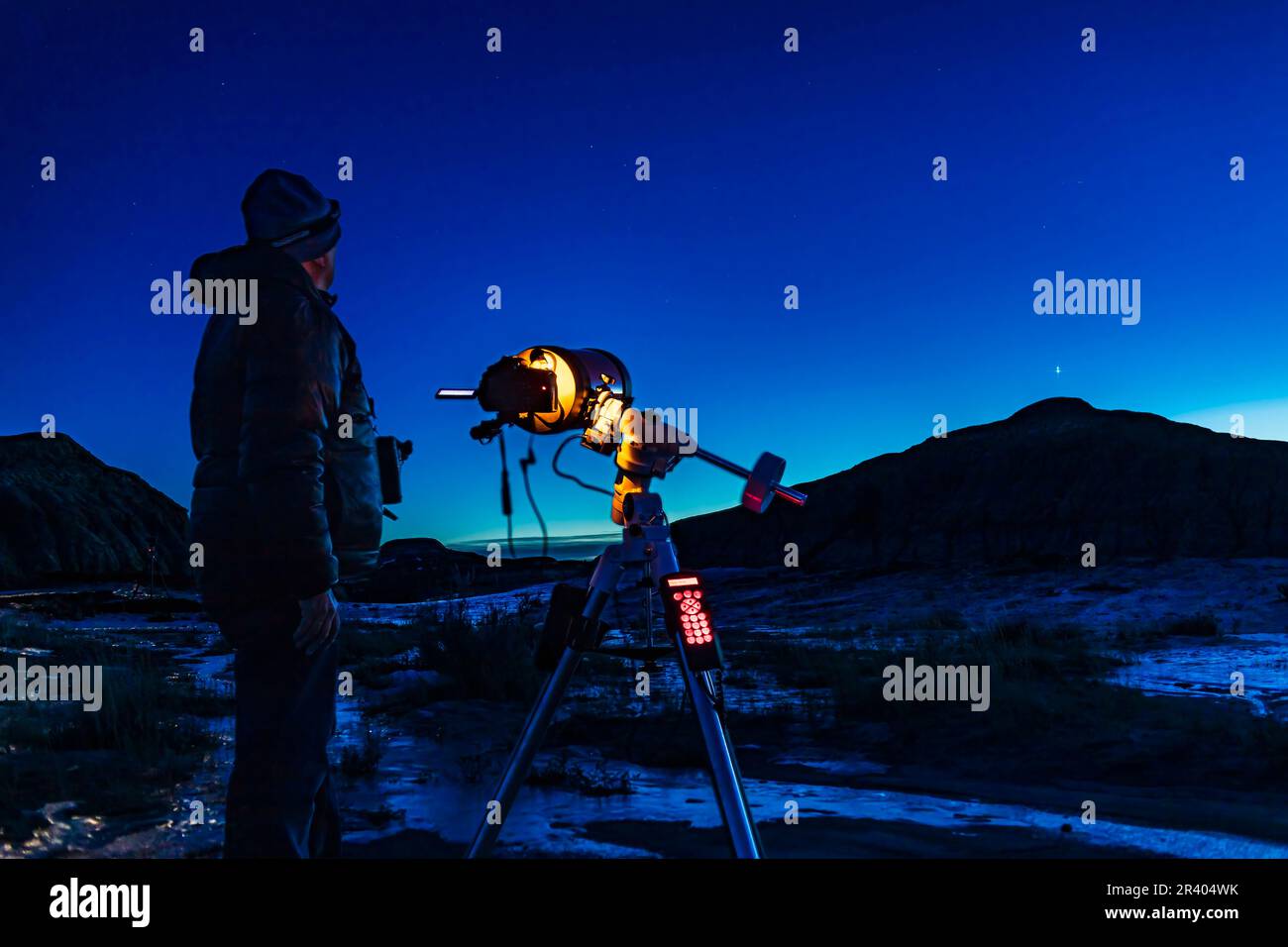 Un astronomo che spara la grande congiunzione di Giove e Saturno al Dinosaur Provincial Park, Alberta, Canada. Foto Stock