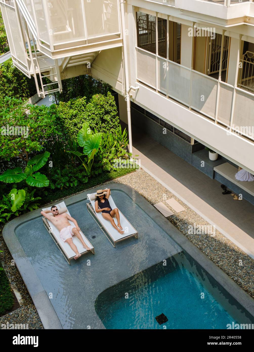 Coppia in una piscina in un hotel di lusso art deco dagli anni '80s Foto Stock