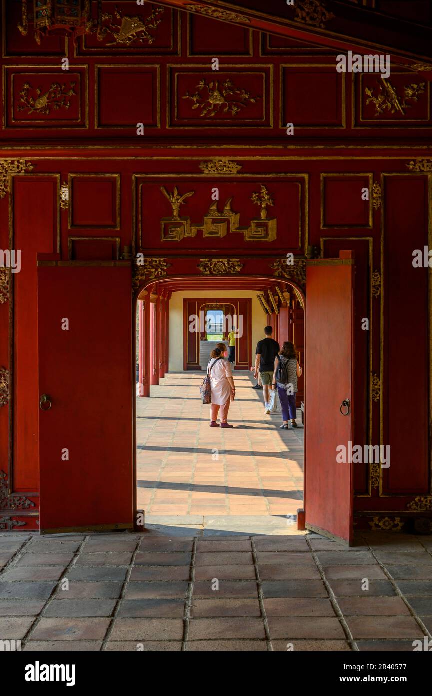 Una guida turistica e visitatori nelle lunghe gallerie del Palazzo Can Chanh nella Cittadella di Hue, città imperiale del Vietnam. Foto Stock