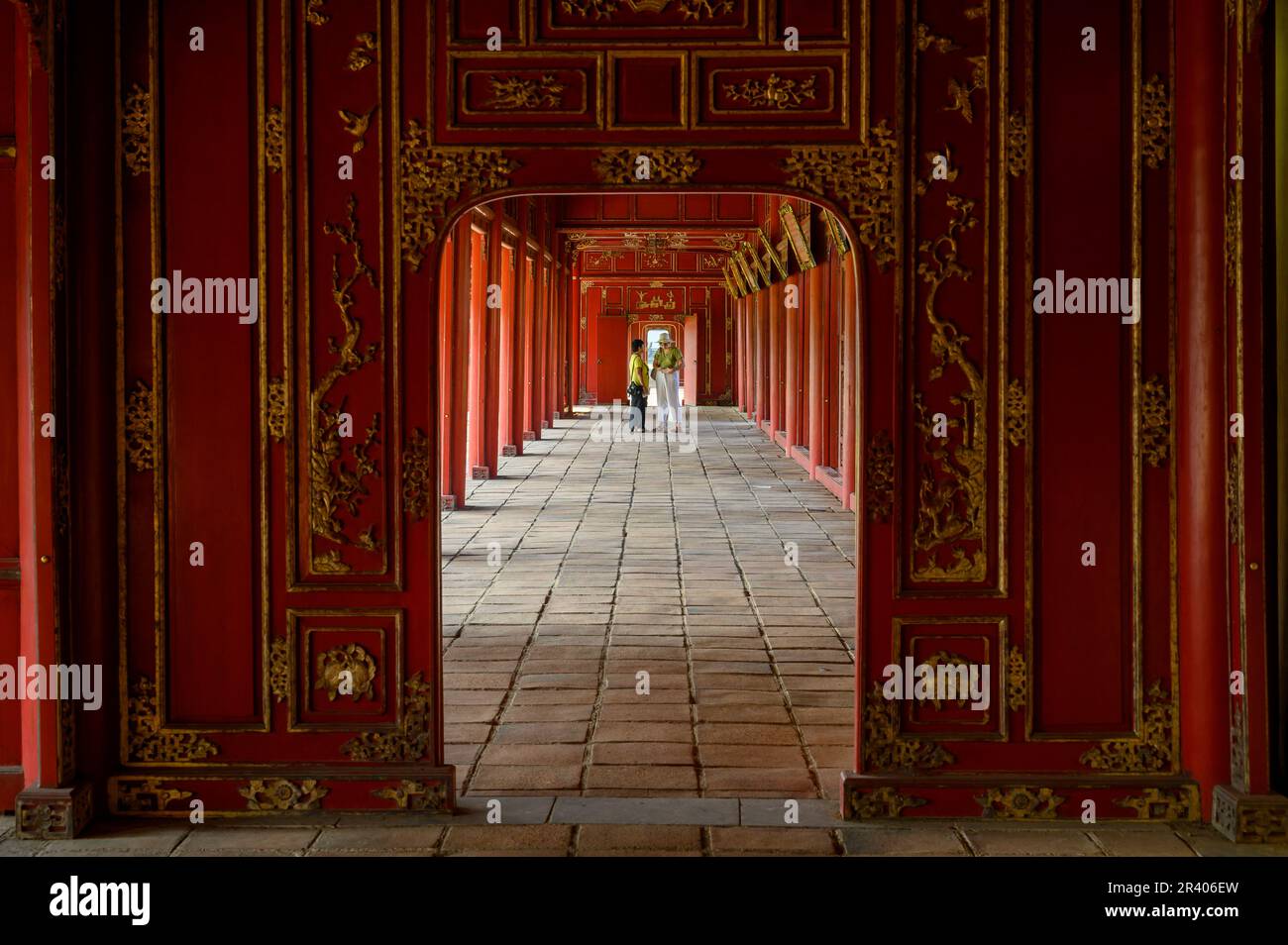 Lunghe gallerie d'oro e dipinte di rosso del Palazzo Can Chanh nella Cittadella di Hue, città imperiale del Vietnam. Foto Stock