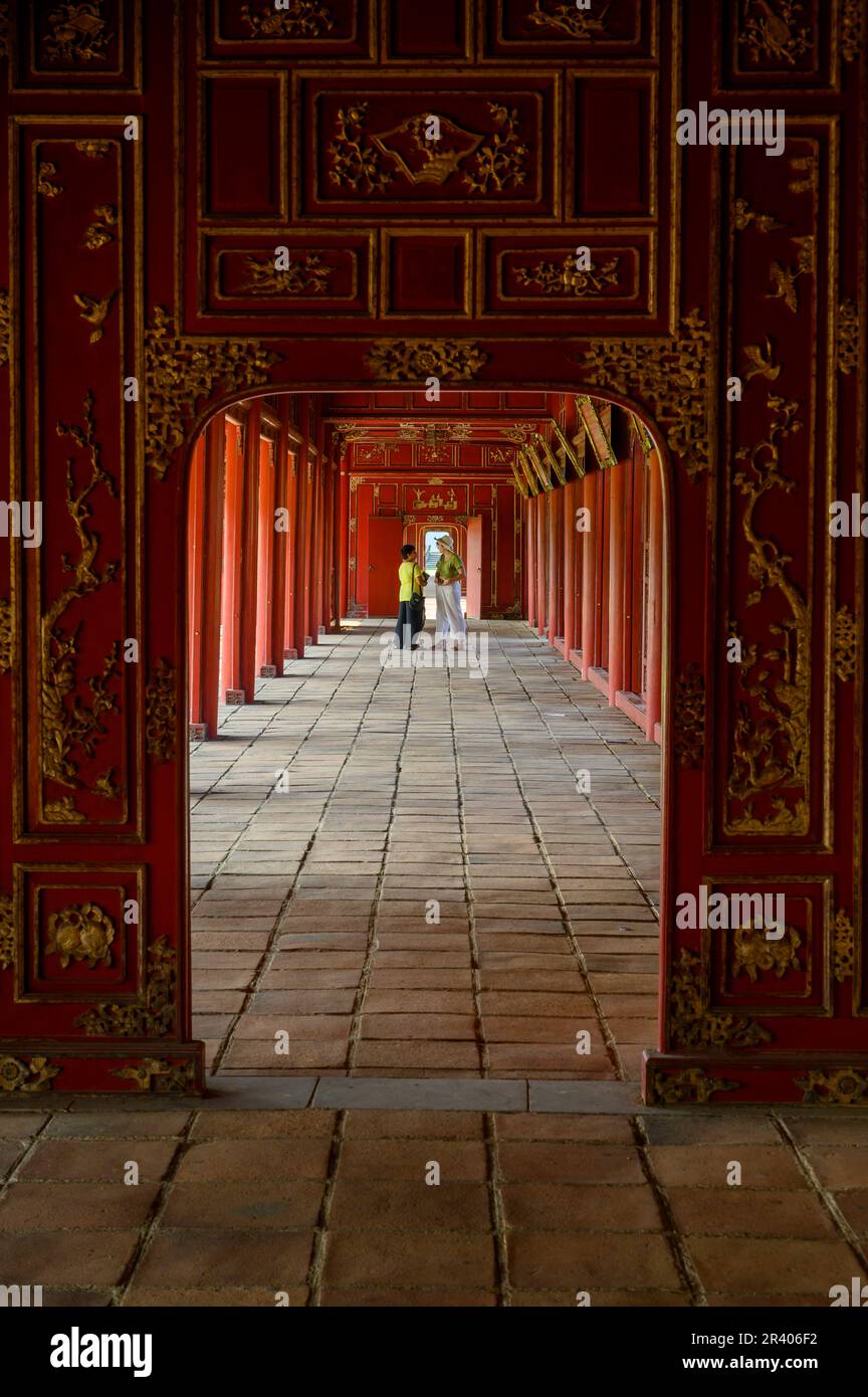 Lunghe gallerie d'oro e dipinte di rosso del Palazzo Can Chanh nella Cittadella di Hue, città imperiale del Vietnam. Foto Stock