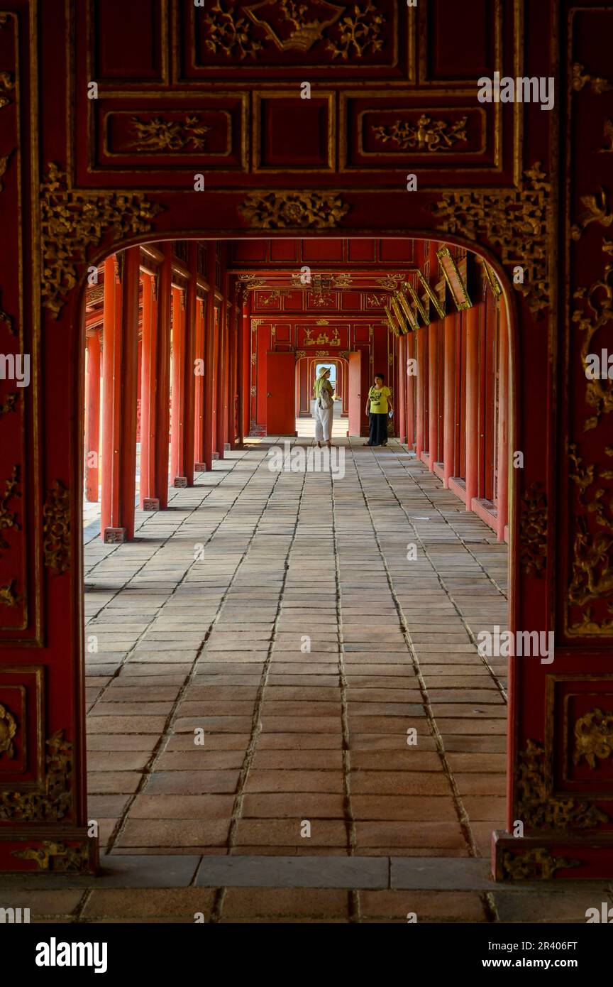 Lunghe gallerie d'oro e dipinte di rosso del Palazzo Can Chanh nella Cittadella di Hue, città imperiale del Vietnam. Foto Stock