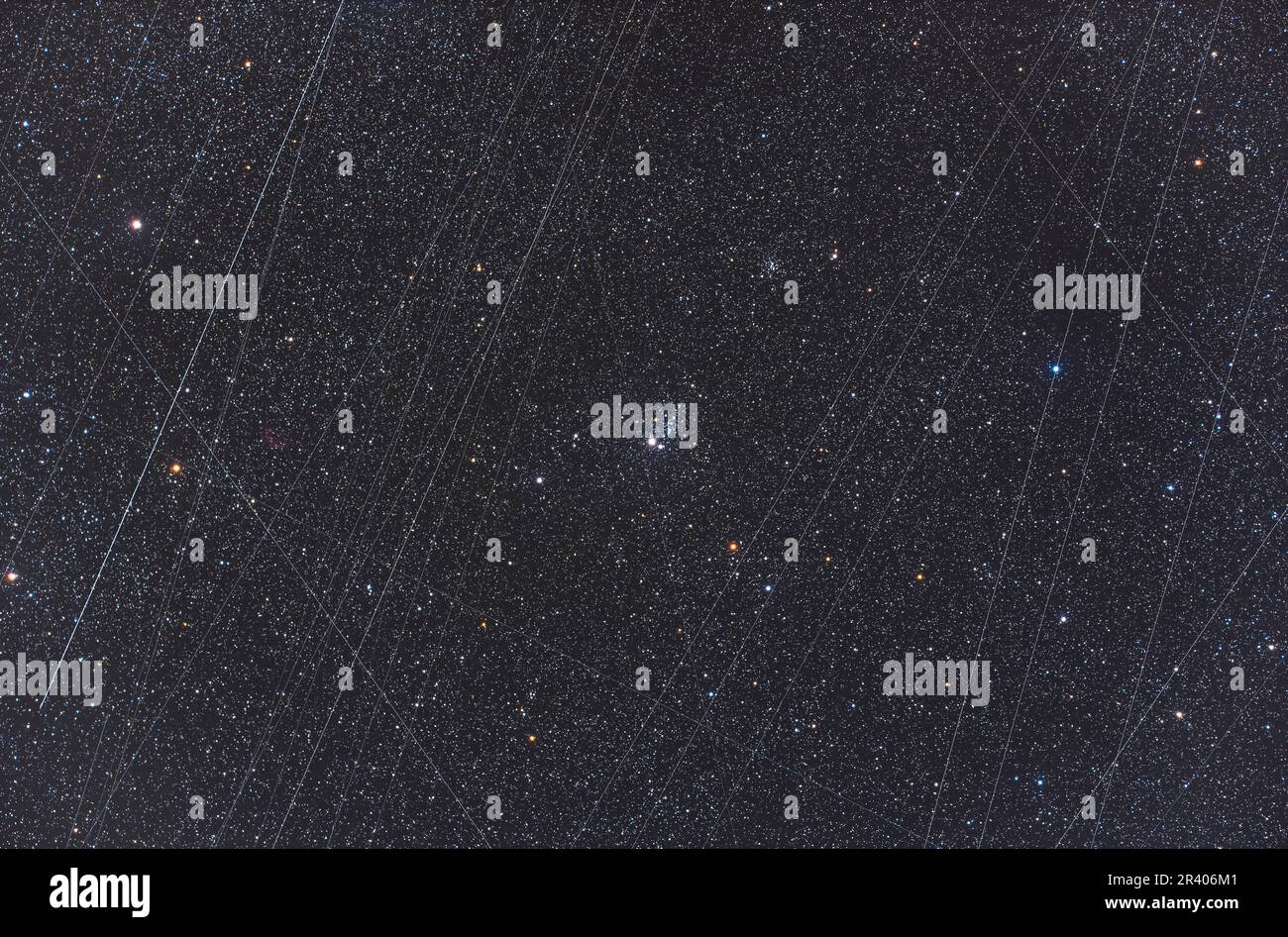NGC 457, il cluster Owl in Cassiopea, con tracce satellitari accumulate. Foto Stock