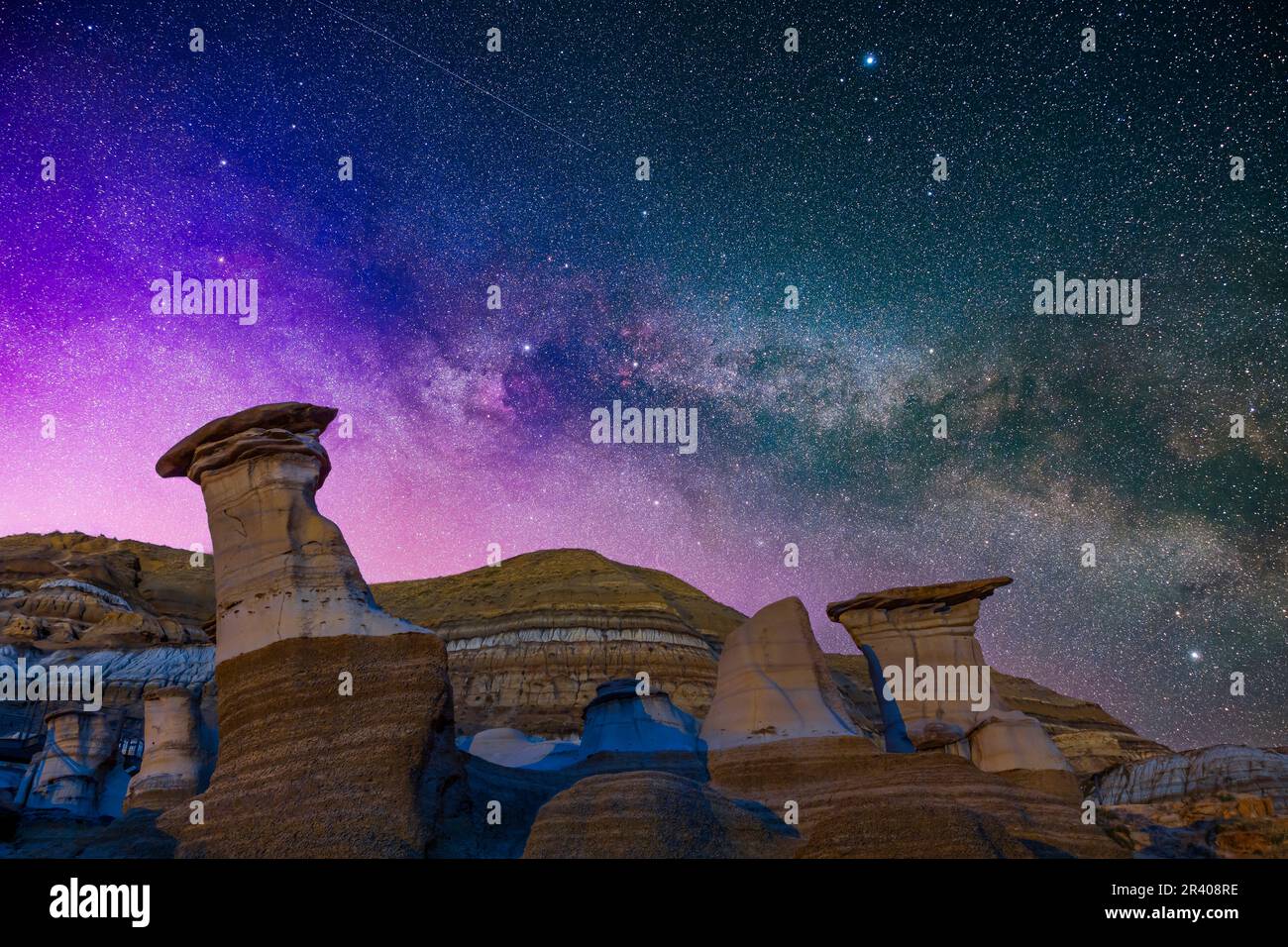 La Via Lattea estiva in Cygnus che sorge sulle formazioni di Hoodoo vicino a Drumheller, Alberta, Canada. Foto Stock