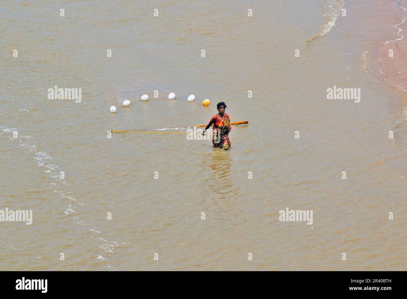 Pescatori e donne stanno lavorando per catturare gamberi nel fiume nella calda mattina di sole. Foto Stock